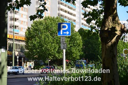 Schild Parkplatz nach rechts, mit Straßensituation im Hintergrund